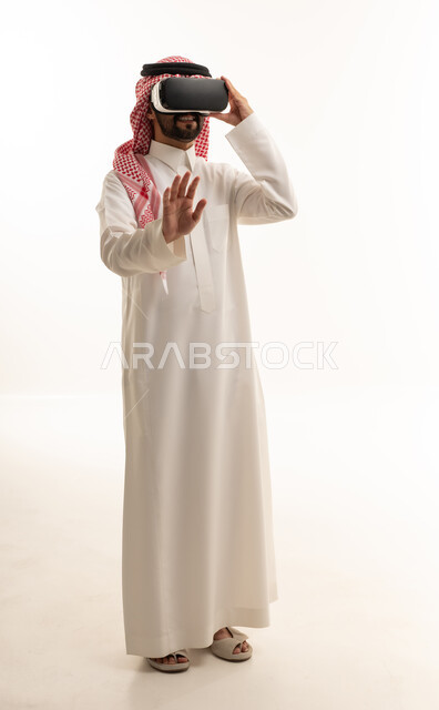 رجل سعودي يستخدم سماعة الواقع الافتراضي بخلفية بيضاء