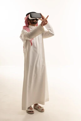 رجل سعودي يستخدم نظارة الواقع الافتراضي بخلفية بيضاء