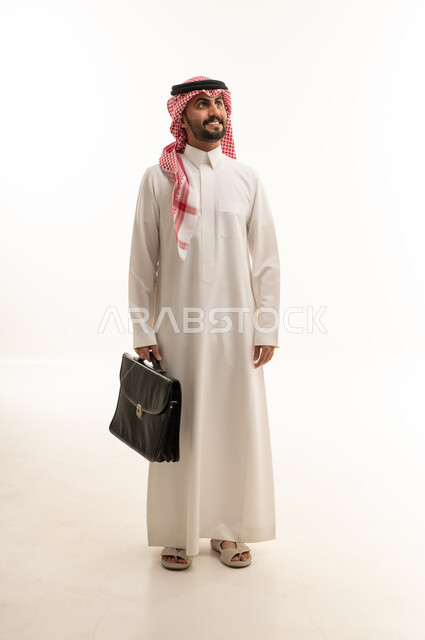 رجل اعمال عربي سعودي خليجي يرتدي الزي الثوب الابيض والشماغ ويحمل حقيبة اللابتوب, ايماءات واشارات مختلفه , كامل الجسم, خلفيه بيضاء