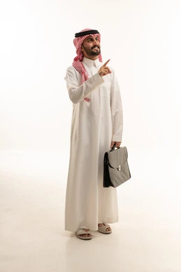 رجل أعمال سعودي يشير بيده مع حقيبة عمل