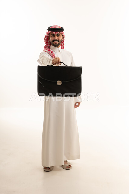 رجل أعمال سعودي يحمل حقيبة سوداء على خلفية بيضاء