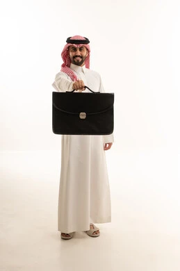 رجل أعمال سعودي يحمل حقيبة سوداء على خلفية بيضاء