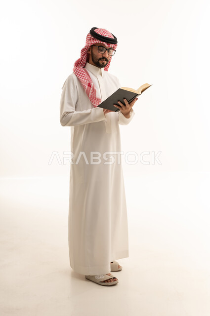 رجل سعودي يقرأ كتاباً في الاستوديو