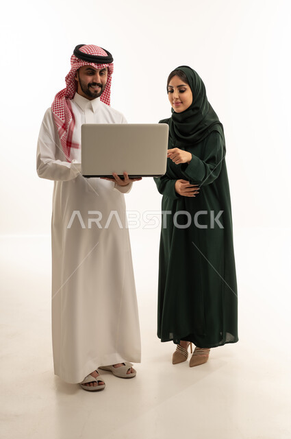 زملاء عمل سعوديون محترفون يستخدمون الحاسوب المحمول