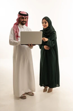 زملاء عمل سعوديون محترفون يستخدمون الحاسوب المحمول