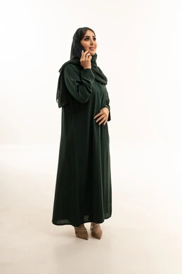 Saudi Woman in Green Abaya Using Smartphone in Studio