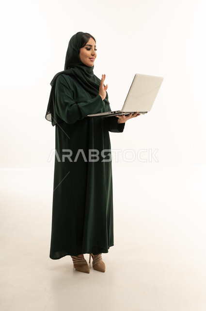 Saudi Woman in Green Abaya Using Laptop on White