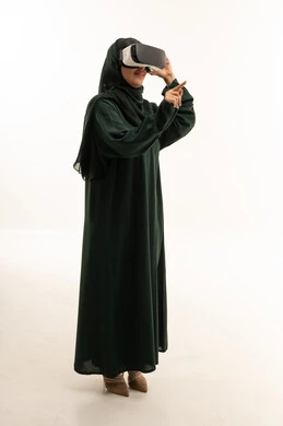 امرأة سعودية بالعباءة تستخدم نظارة الواقع الافتراضي