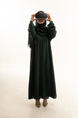 امرأة عربية بالعباءة تستخدم نظارة الواقع الافتراضي