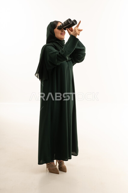 امرأة سعودية بالعباءة تنظر عبر المنظار