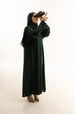 امرأة سعودية بالعباءة تنظر عبر المنظار