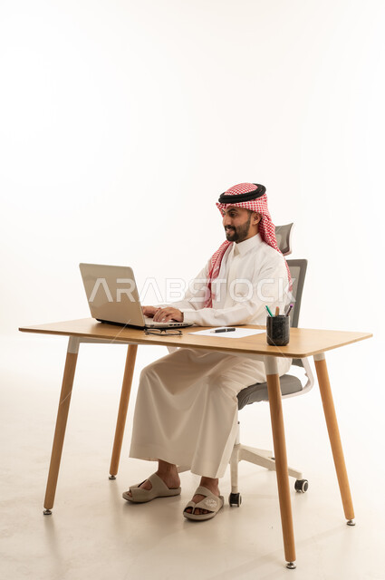 رجل أعمال سعودي يعمل على اللابتوب في مكتب حديث