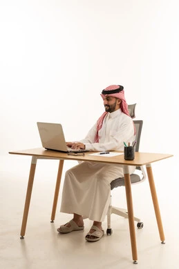 رجل أعمال سعودي يعمل على اللابتوب في مكتب حديث