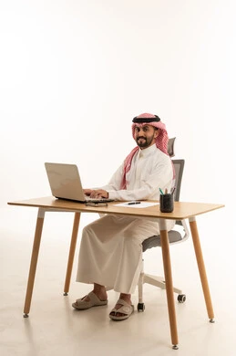 رجل أعمال سعودي يستخدم اللابتوب على مكتب العمل