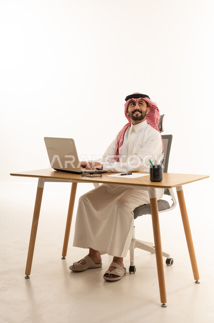 Saudi Man Working on Laptop at Office Desk Studio