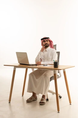 رجل أعمال سعودي يفكر خلف مكتب العمل