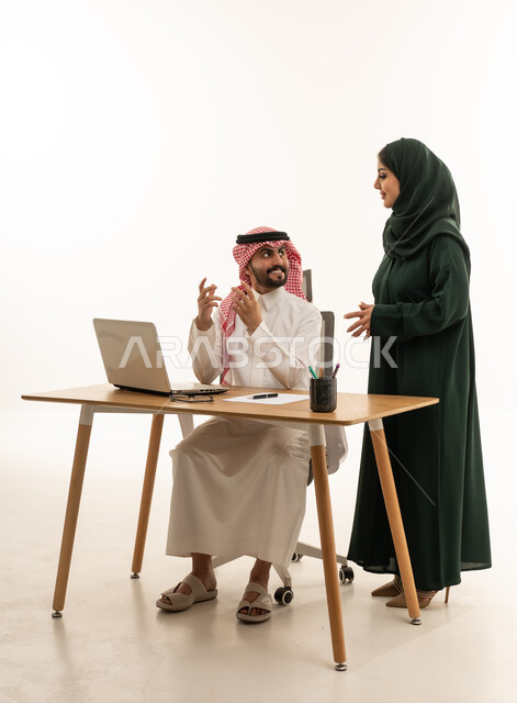 زملاء عمل سعوديون يتناقشون في المكتب أمام كمبيوتر