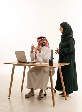 زملاء عمل سعوديون يتناقشون في المكتب أمام كمبيوتر