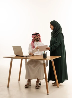 زملاء عمل سعوديون يناقشون وثيقة في المكتب