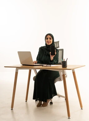 سيدة أعمال سعودية مع لابتوب وهاتف في استوديو