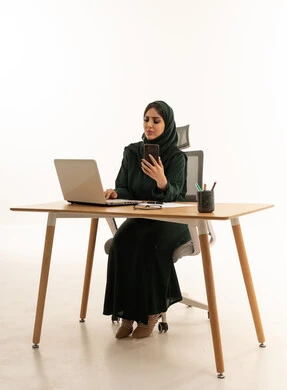 سيدة أعمال سعودية تعمل على المكتب بالكمبيوتر