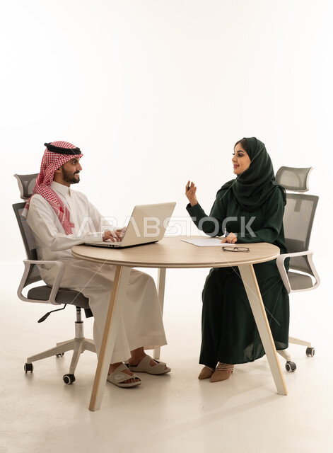 اجتماع عمل بين رجل وسيدة سعوديين في مكتب عصري