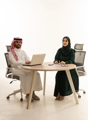 رجال وسيدات أعمال سعوديون مع لابتوب في استوديو