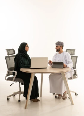 رجل أعمال عماني وسيدة أعمال عربية في اجتماع عمل