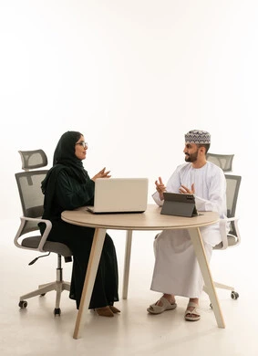 اجتماع عمل عُماني مع كمبيوتر محمول وجهاز لوحي