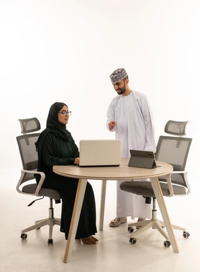 موظفون عمانيون يعملون على كمبيوتر محمول في مكتب