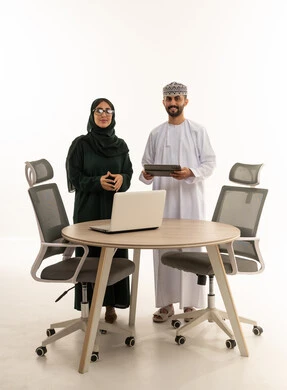 رجال وسيدات أعمال عمانيون في المكتب مع تقنيات حديثة