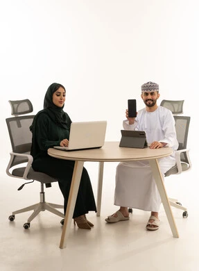 رجل أعمال عماني وامرأة عربية مع أجهزة حديثة