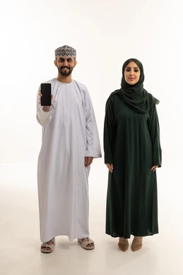 زوجين عُمانيين مع هاتف ذكي على خلفية بيضاء