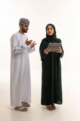 رجل وامرأة من عمان يستخدمان جهاز لوحي