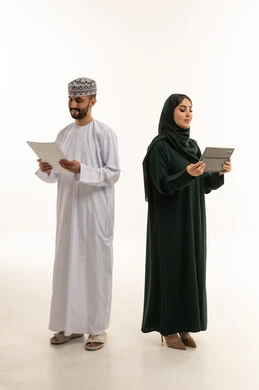 مهنيون عمانيون مع جهاز لوحي ووثيقة في الاستوديو