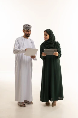 موظفون عمانيون مع جهاز لوحي بخلفية بيضاء