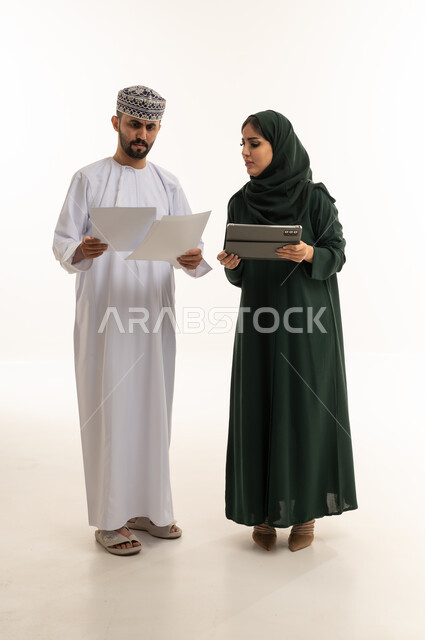 محترفو أعمال عمانيون مع جهاز لوحي وأوراق