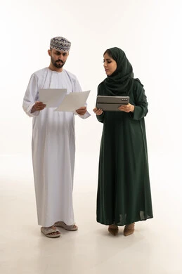 محترفو أعمال عمانيون مع جهاز لوحي وأوراق