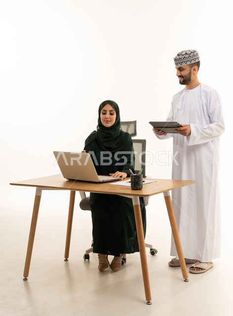 موظفون عمانيون يعملون باستخدام الحاسوب والجهاز اللوحي