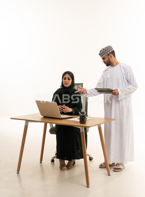 Omani Business Colleagues Working on Laptop in Office