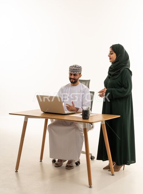 رجل وامرأة من عمان يعملان على لاب توب في استوديو