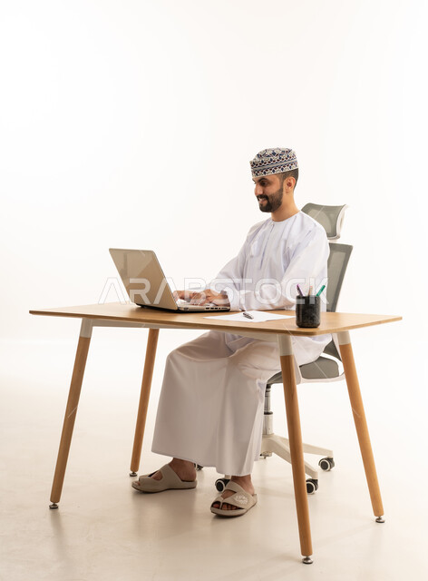 Omani Professional Using Laptop at Office Desk