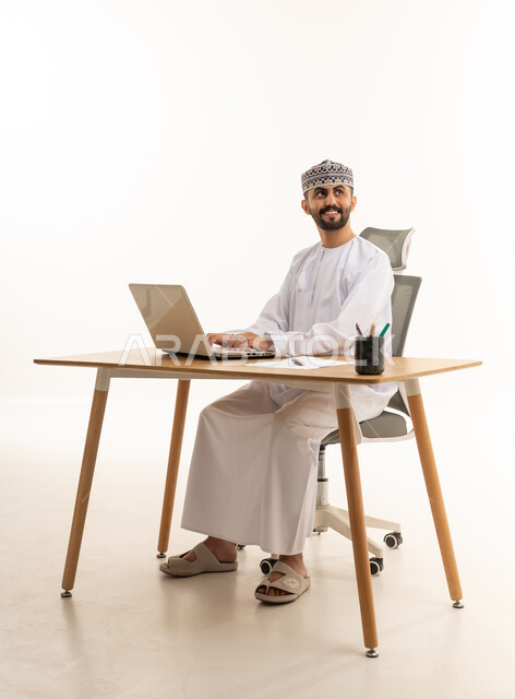 Omani Man Working on Laptop in Studio Office