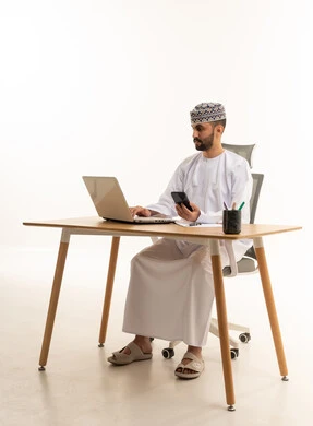 رجل أعمال عماني يعمل على لاب توب في المكتب