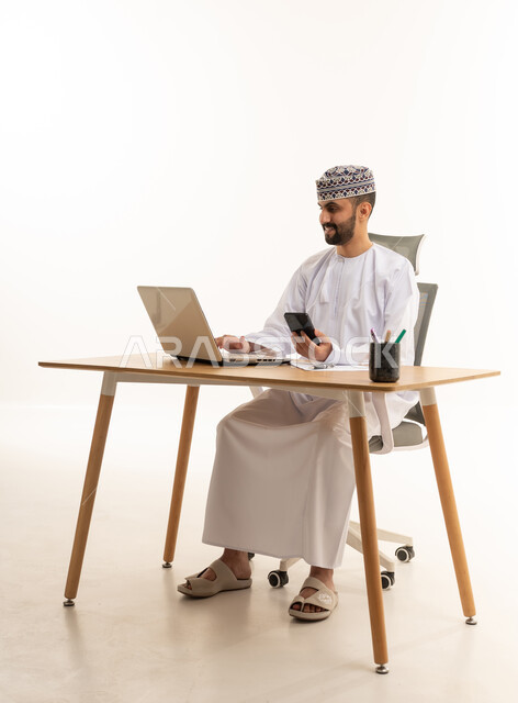 رجل أعمال عماني يعمل على الكمبيوتر المحمول