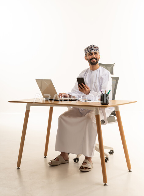 Omani Professional with Laptop and Smartphone in Studio