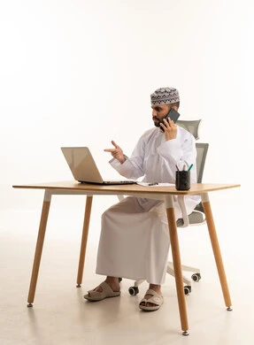 رجل أعمال عُماني يستخدم المحمول والهاتف على خلفية بيضاء