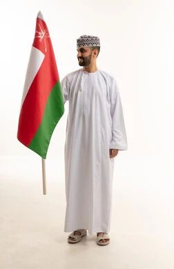 رجل عماني يحمل العلم الوطني على خلفية بيضاء