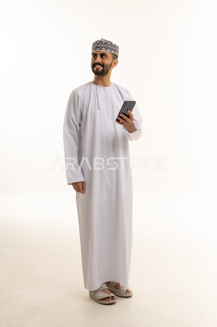 Omani Man Holding Smartphone on Plain White Background