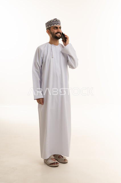 Omani Man in Traditional Dress Talking on Smartphone